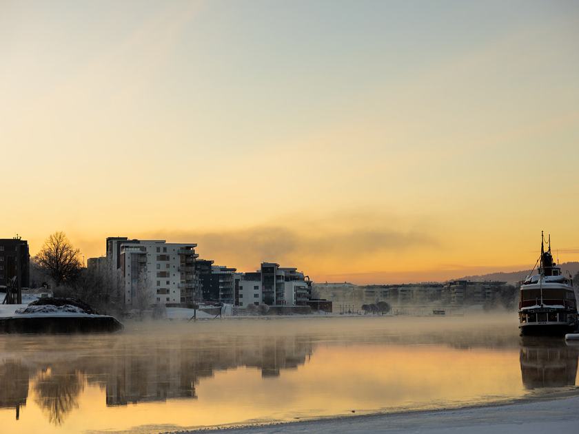 Hjellevannet en frostklar morgen, med frostrøyk over vannet og byen i motlys